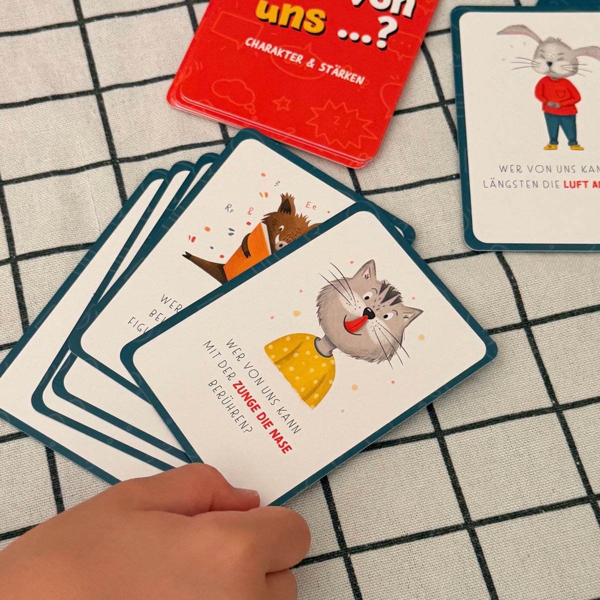 Wer von uns? Kartenspiel für Kinder – gemeinsam Stärken entdecken mit 40 liebevoll illustrierten Karten Kategorien Familie & Miteinander, Charakter & Stärken, Abenteuer & Mut, Spaß & Lachen Zunge mit Nase berühren